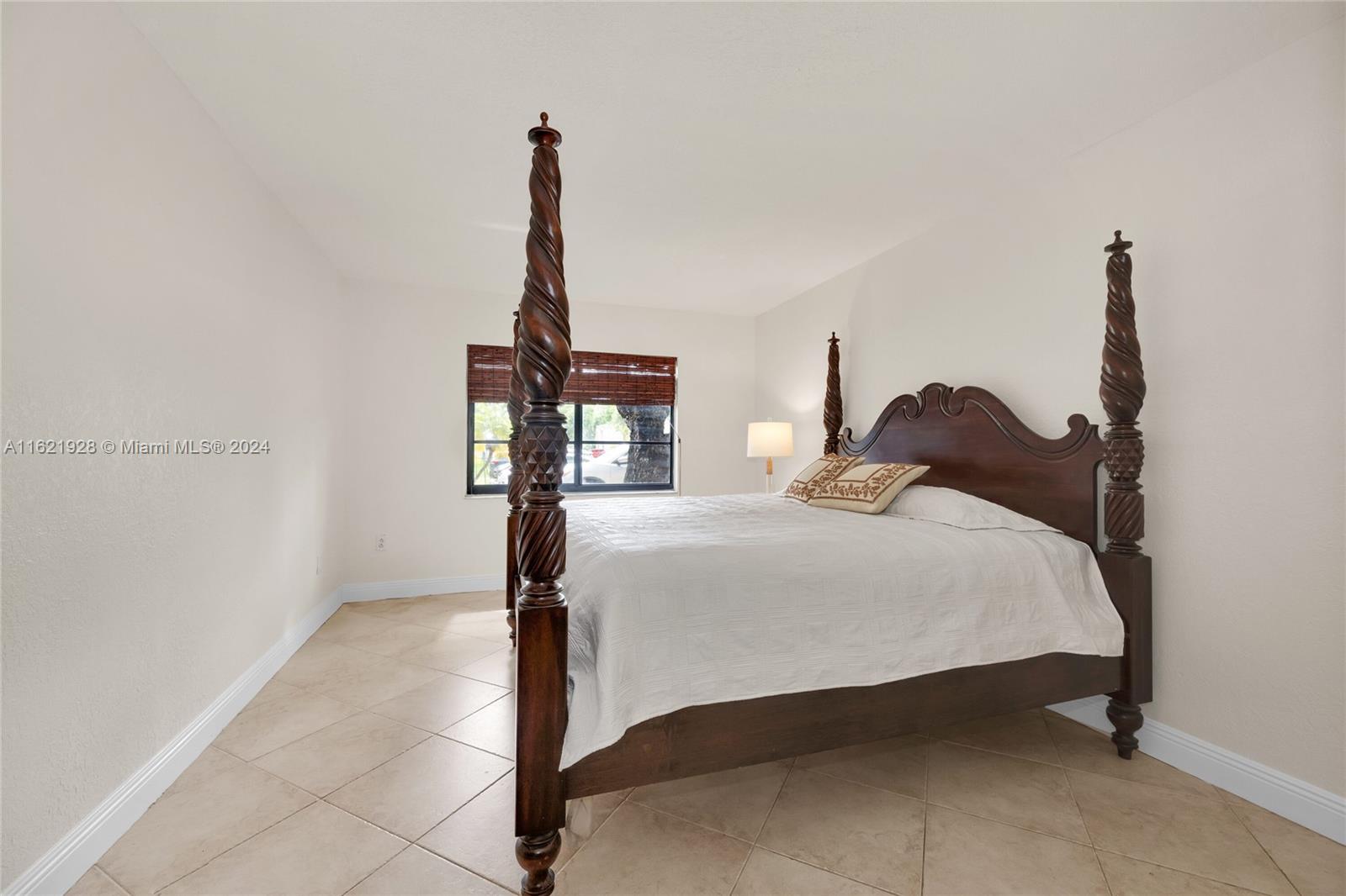 7927 Southwest 104th Street, Unit 108E Miami, FL 33156 - Photo 7 of 17 a bedroom with a bed and a table