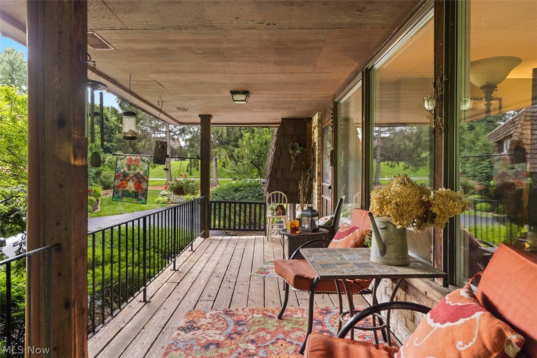 171 Granger Road, Unit 107 Medina, OH 44256 - Photo 7 of 41 Covered outdoor porch featuring wood-finish flooring, a wood-paneled ceiling, and a black metal railing