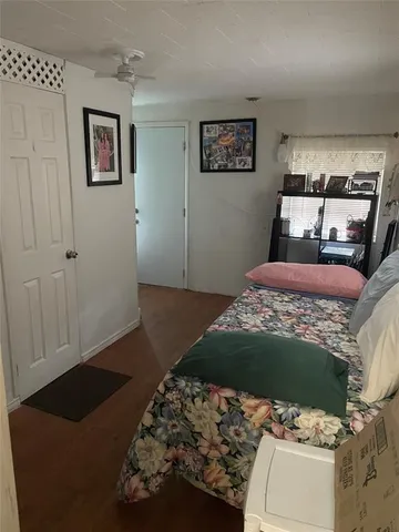 a bedroom with a bed and a lamp on dresser