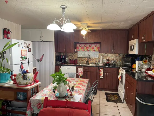 a kitchen with stainless steel appliances granite countertop a stove a refrigerator a sink dishwasher and white cabinets with wooden floor