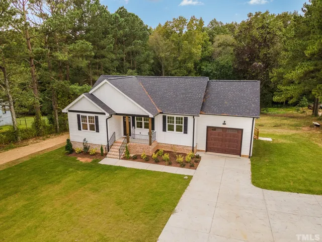 a aerial view of a house with swimming pool in front of big yard