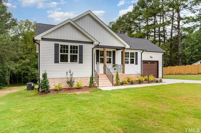 a view of a house with a yard and trees