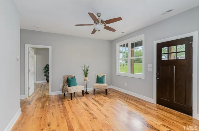 a living room with furniture and window with wooden floor
