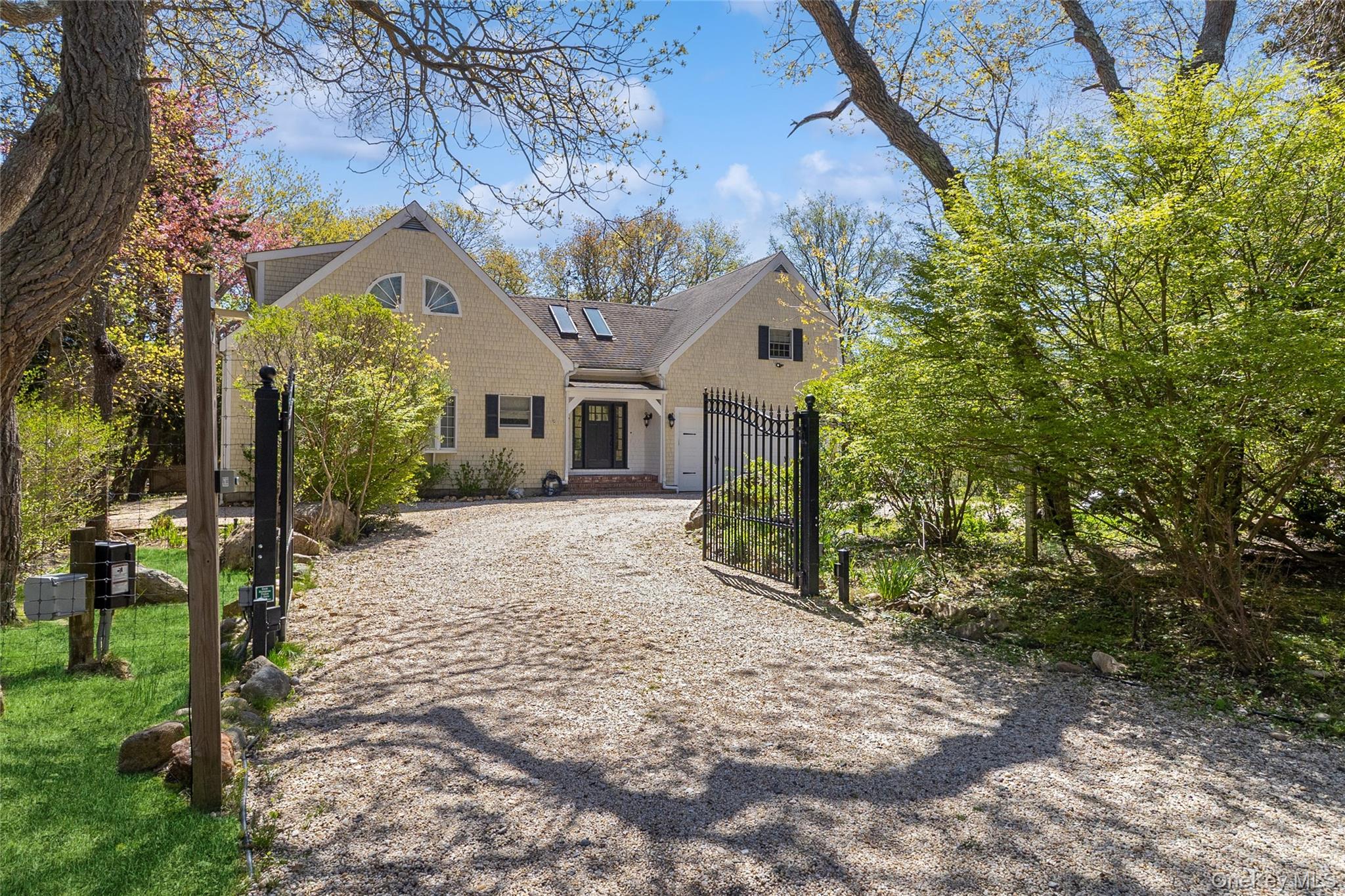 91 Sunset Beach Road Sag Harbor, NY 11963 - Photo 1 of 16 a front view of a house with a yard and garage