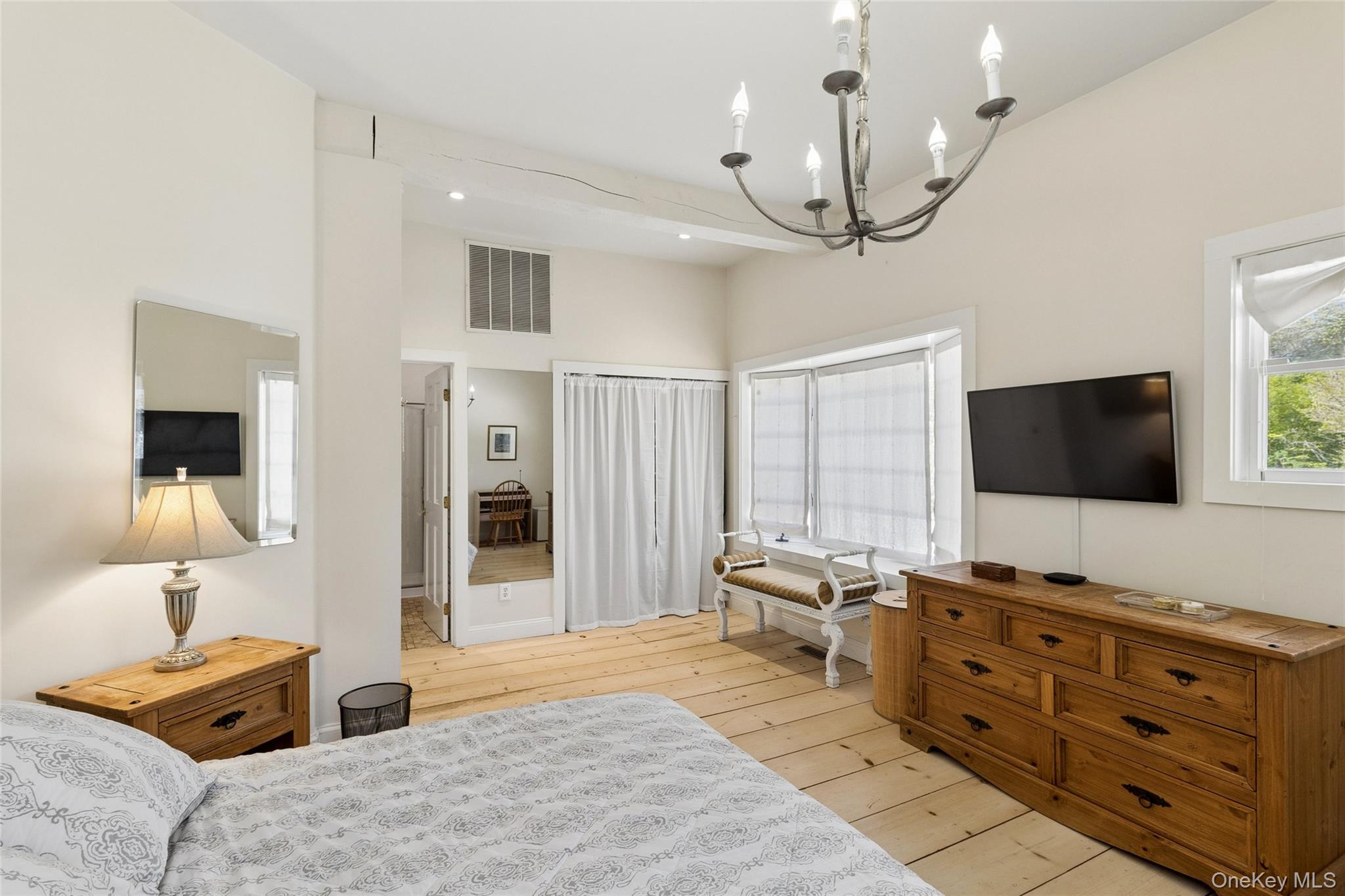 91 Sunset Beach Road Sag Harbor, NY 11963 - Photo 10 of 16 a spacious bedroom with a bed and a flat screen tv