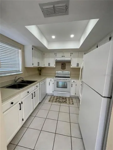 a kitchen with a refrigerator a sink and a stove top oven