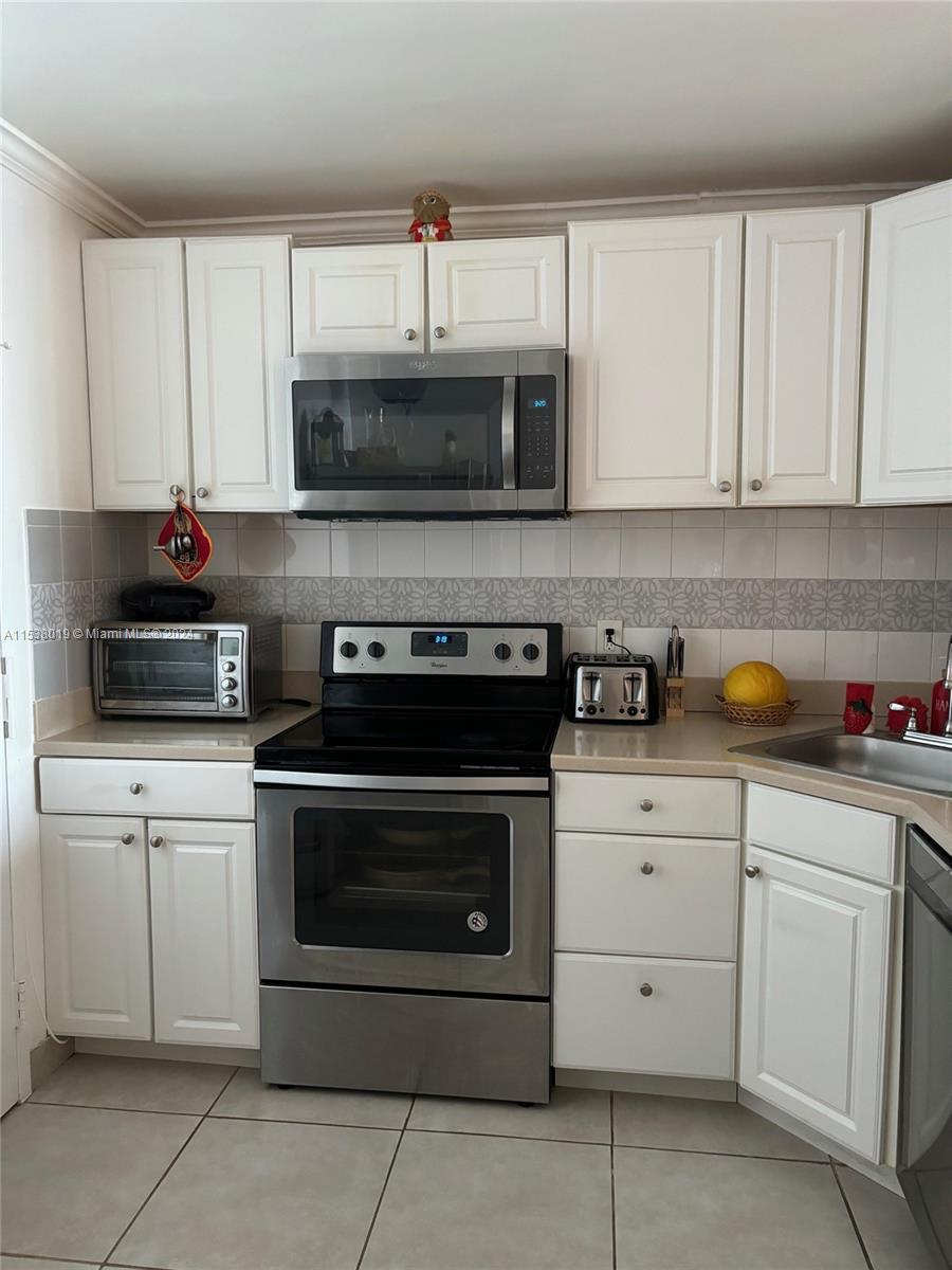 a kitchen with cabinets stainless steel appliances and a sink