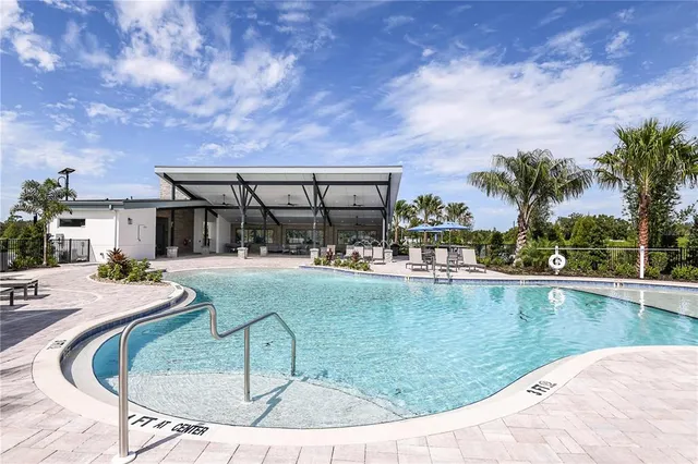 swimming pool view with a seating space and a garden