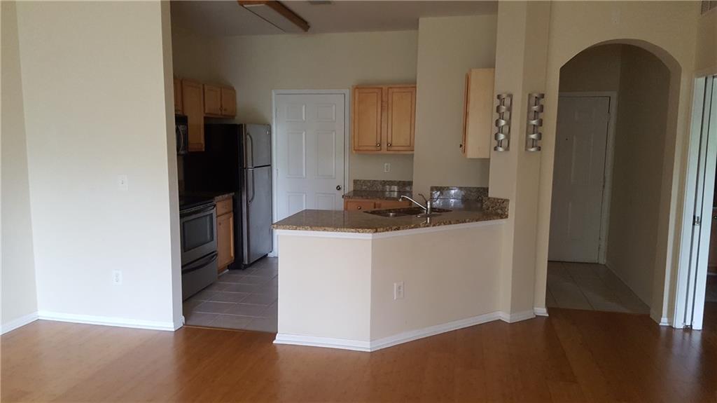 5641 Roswell Road, Unit 106 Atlanta, GA 30342 - Photo 3 of 5 a kitchen with a refrigerator and a stove top oven