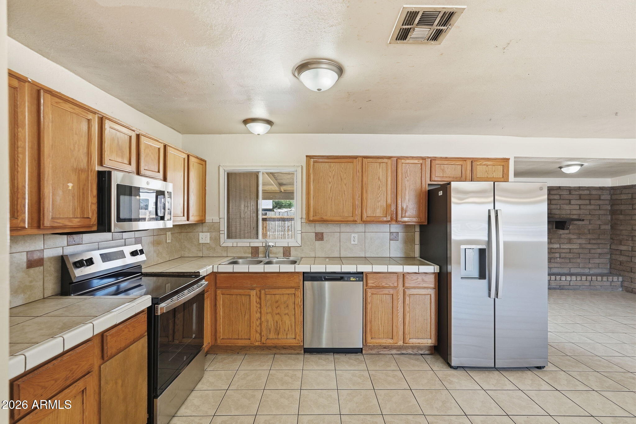 6452 West Thomas Road Phoenix, AZ 85033 - Photo 13 of 30 a kitchen with stainless steel appliances granite countertop a refrigerator a sink a stove top oven a counter space and cabinets
