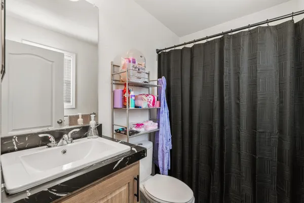 a bathroom with a sink vanity mirror and toilet