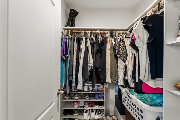a view of walk in closet with clothes and shoes
