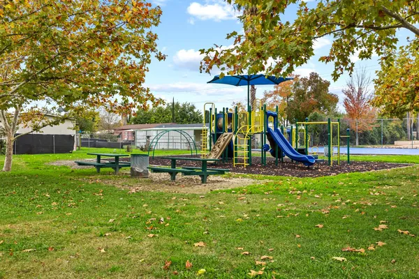 a view of a park with slide and a bench