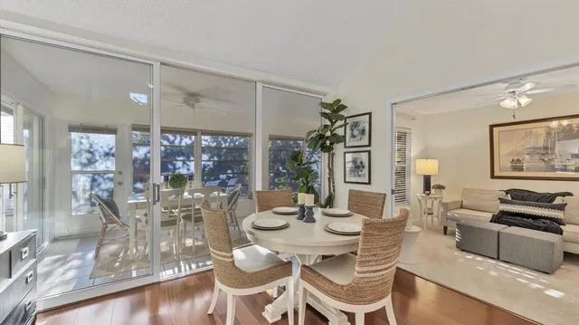 a dining room with wooden floor and large window