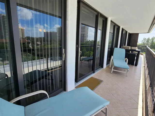 a living room with furniture and a dining table with kitchen view
