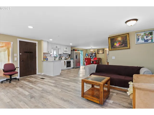 a living room with furniture and a dining table with wooden floor