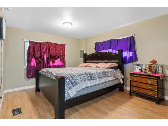 a bedroom with a bed and wooden floor