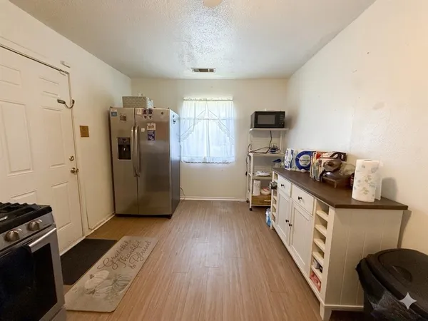 a kitchen with stainless steel appliances granite countertop a refrigerator and a stove top oven