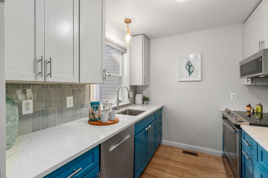334 Beacon Street, Unit B Somerville, MA 02143 - Photo 8 of 23 a kitchen with stainless steel appliances granite countertop a sink a stove and cabinets