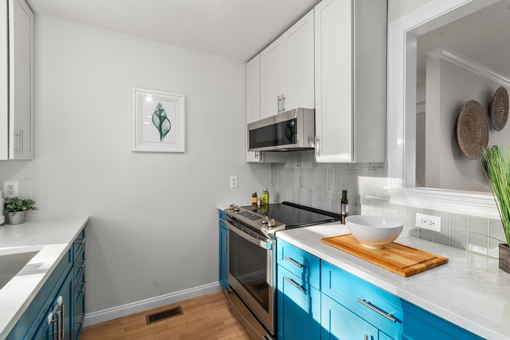 334 Beacon Street, Unit B Somerville, MA 02143 - Photo 9 of 23 a kitchen with stainless steel appliances granite countertop a sink and a stove top oven