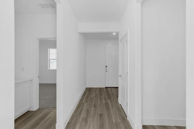 a large white kitchen with kitchen island a sink a center island stainless steel appliances and a window