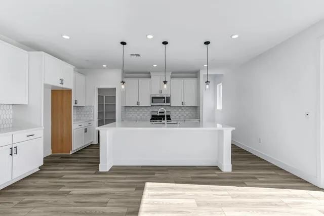 a view of a kitchen with stainless steel appliances granite countertop a white stove top oven and refrigerator