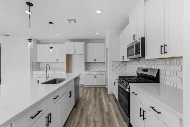 a kitchen with stainless steel appliances granite countertop a sink stove and refrigerator