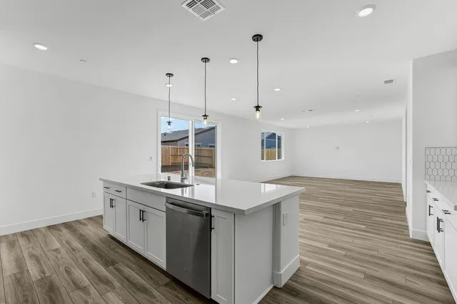 a kitchen with a stove and a wooden floor