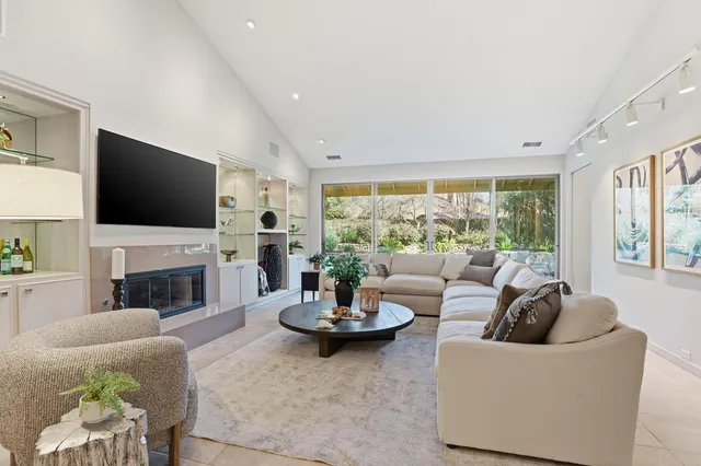 a living room with fireplace furniture and a large window