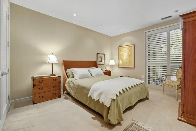 a bedroom with a bed and a lamp on dresser