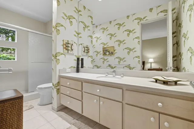 a bathroom with a granite countertop toilet sink and mirror