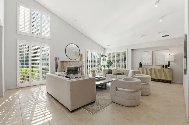 a living room with furniture a table and a large window