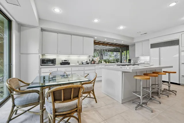a kitchen with granite countertop white cabinets dining table and chairs