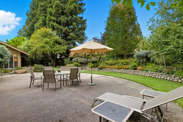 a view of a patio with a table and chairs under an umbrella