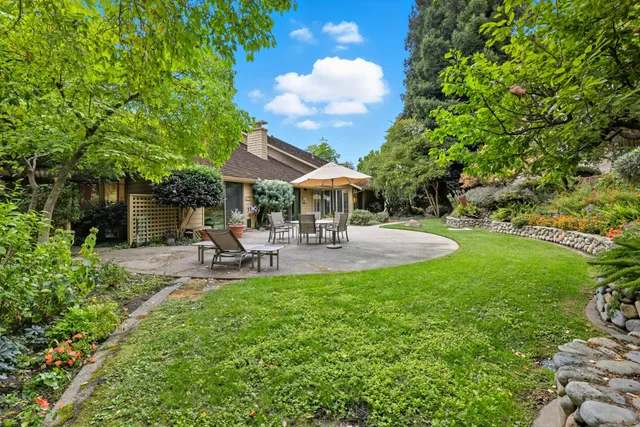 a view of a patio with table and chairs under an umbrella