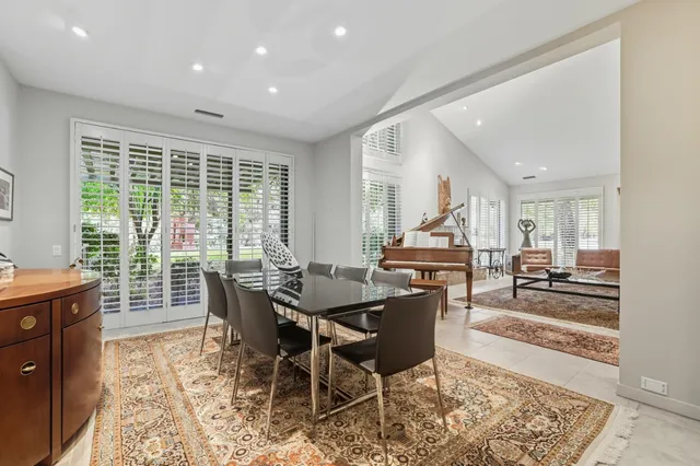 a dining room with furniture a rug and a chandelier