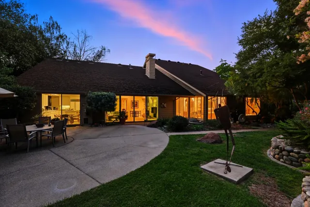 a view of a house with backyard and sitting area