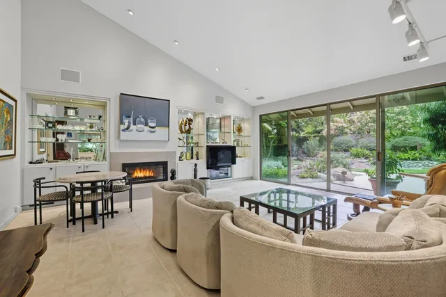 a living room with furniture a fireplace and a large window