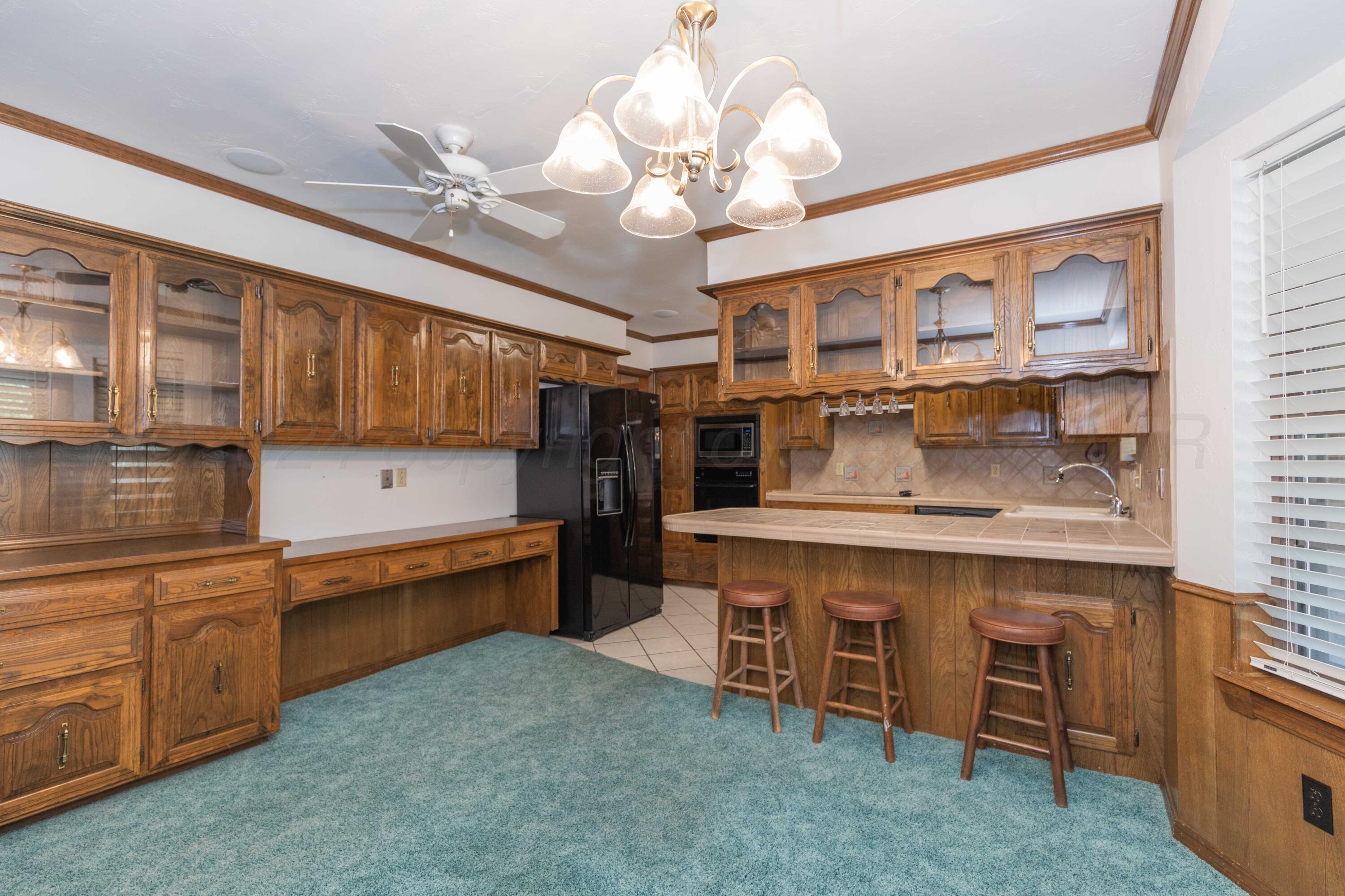 5809 Stone Drive Amarillo, TX 79109 - Photo 15 of 47 a kitchen that has a lot of cabinets in it