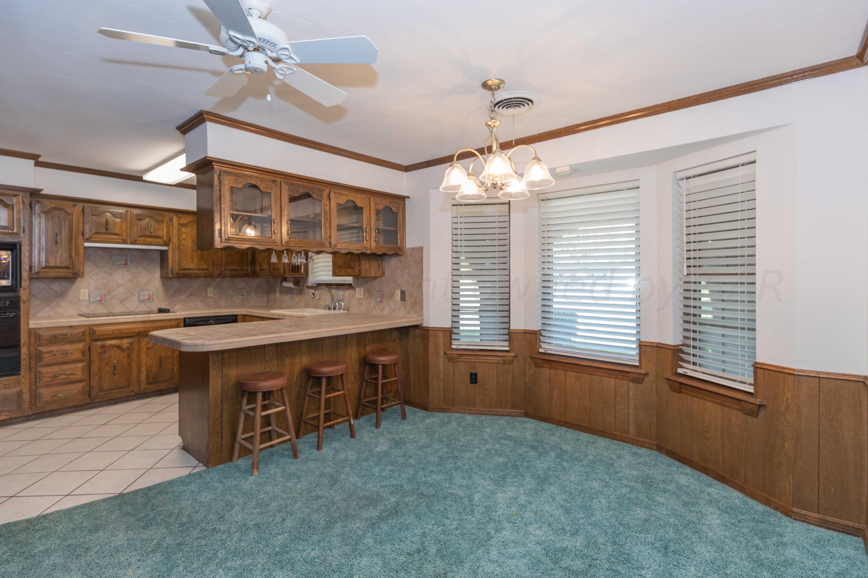 5809 Stone Drive Amarillo, TX 79109 - Photo 16 of 47 a kitchen with granite countertop a stove sink and cabinets