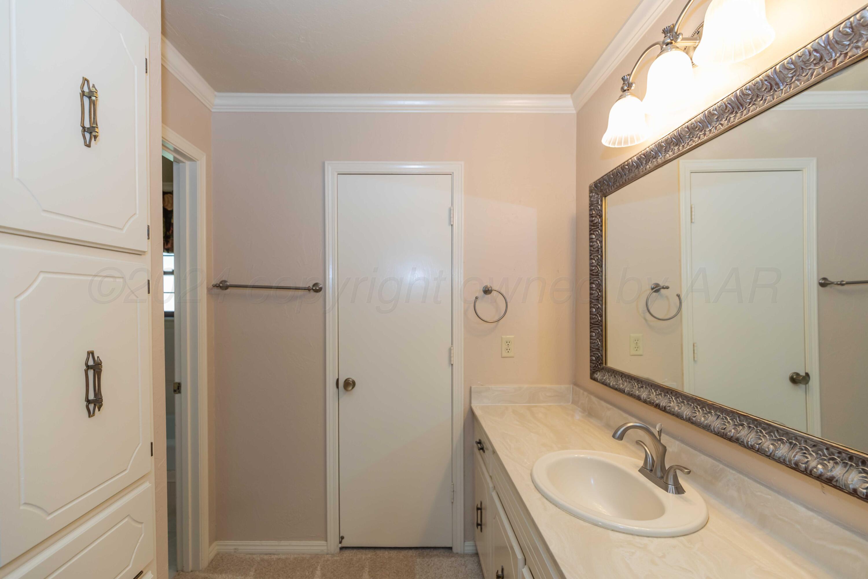 5809 Stone Drive Amarillo, TX 79109 - Photo 24 of 47 a bathroom with a sink and a mirror