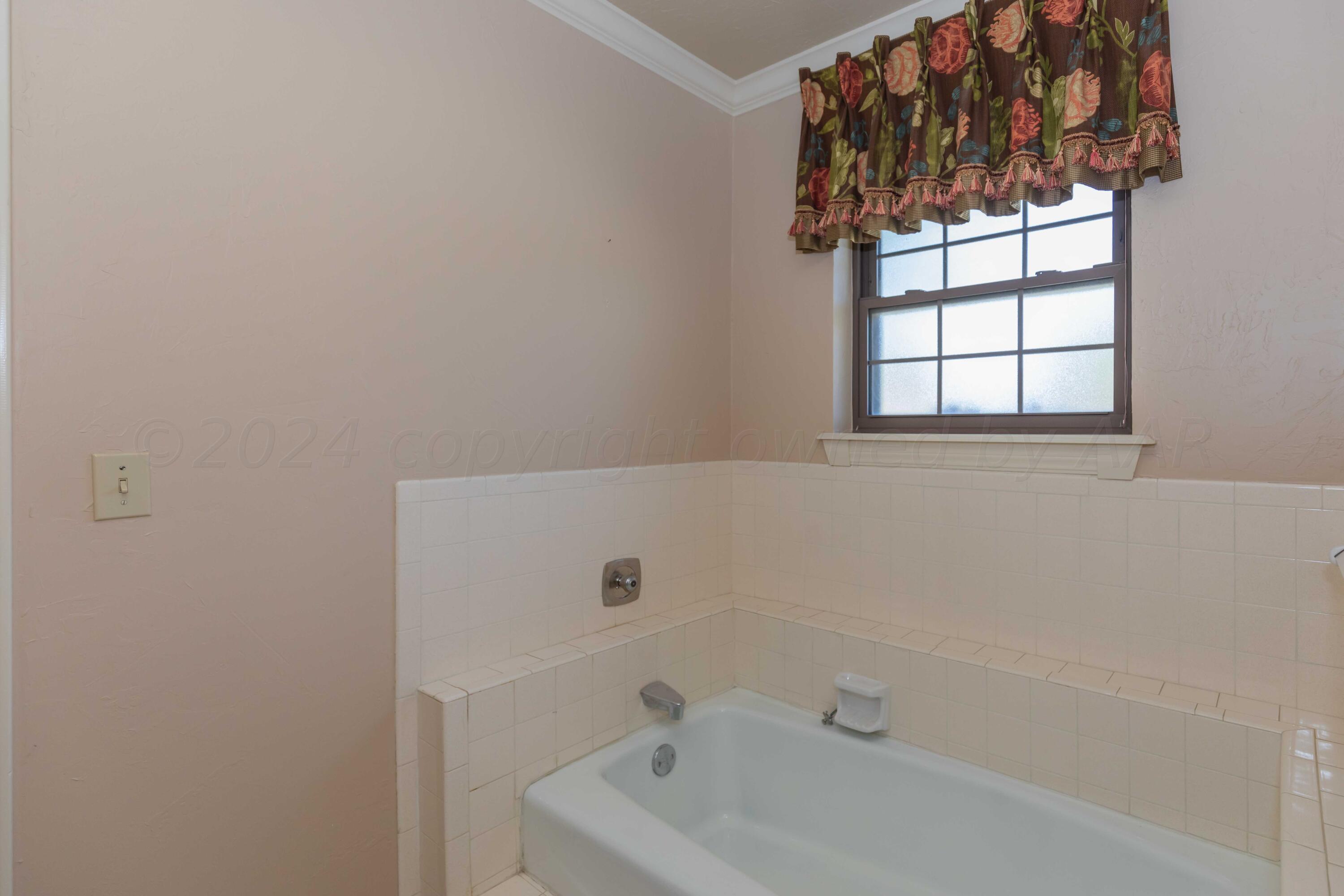 5809 Stone Drive Amarillo, TX 79109 - Photo 27 of 47 a bathroom with a bathtub and window
