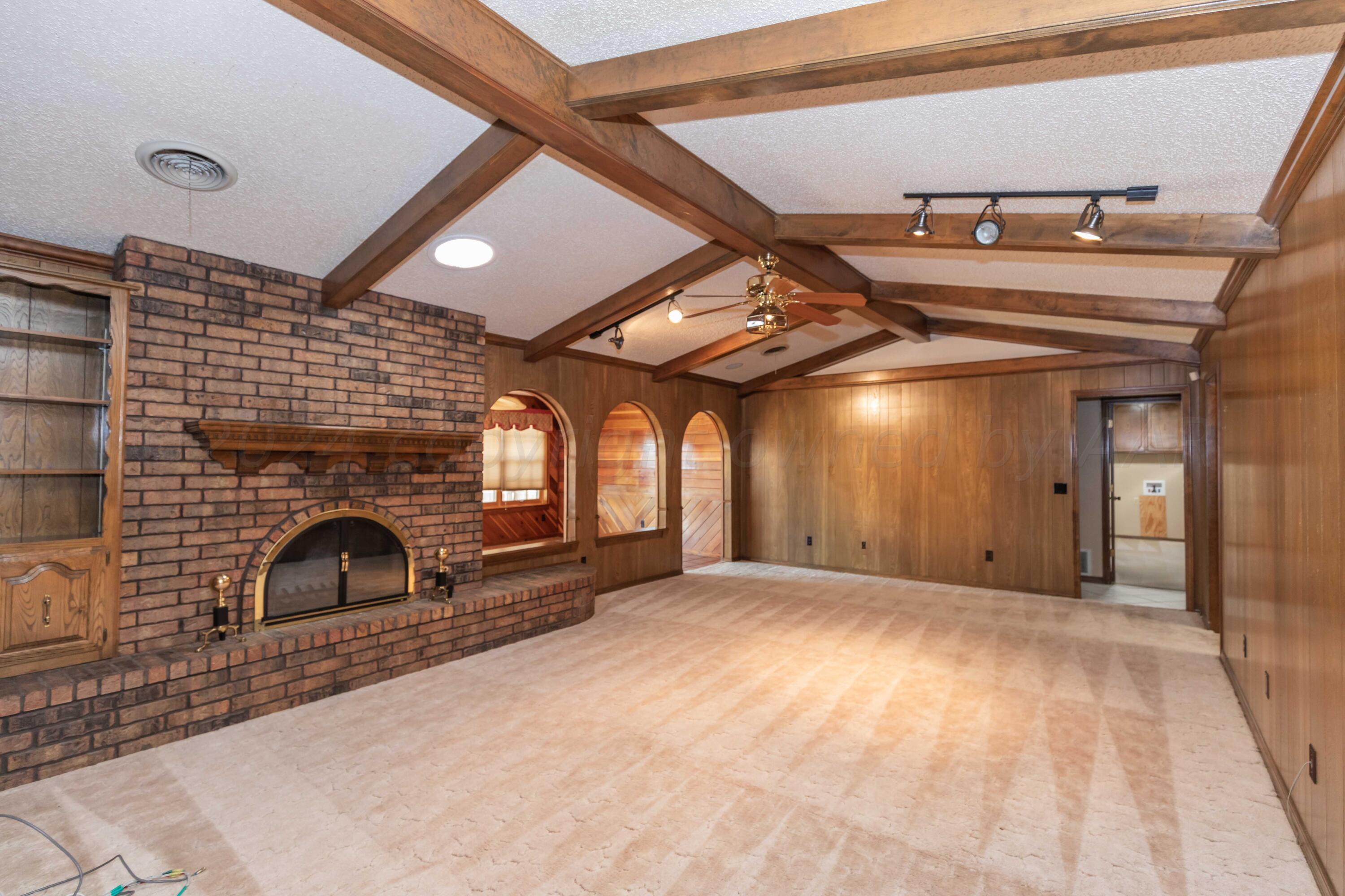 5809 Stone Drive Amarillo, TX 79109 - Photo 8 of 47 a view of an empty room with a fireplace and chandelier