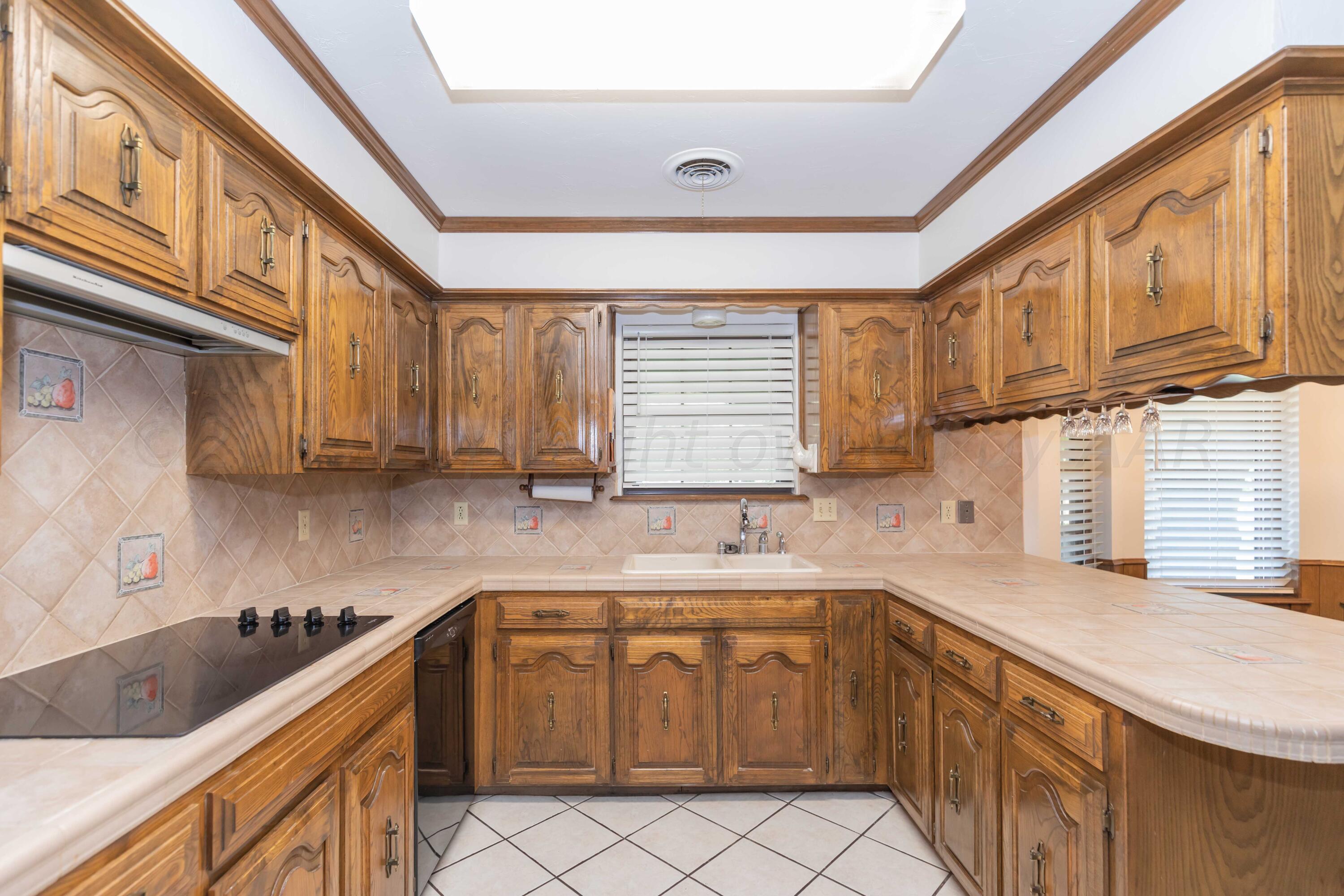 5809 Stone Drive Amarillo, TX 79109 - Photo 10 of 47 a kitchen with a sink cabinets stainless steel appliances and a window