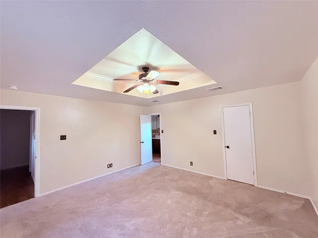 an empty room with a window and a fan