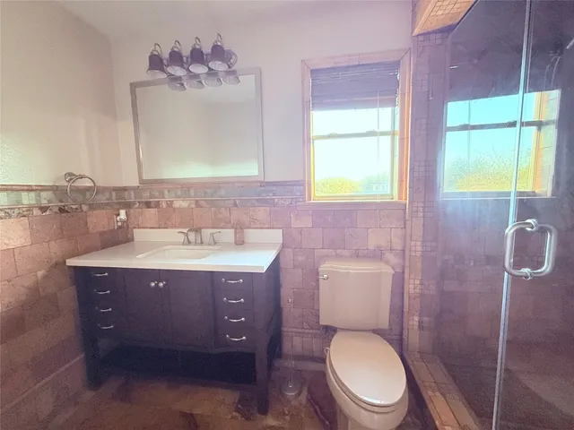 a bathroom with a bathtub shower sink mirror vanity and toilet