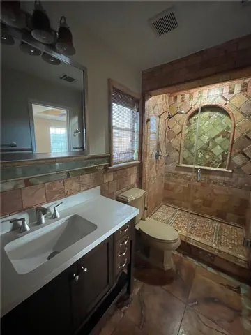 a bathroom with a sink toilet and shower