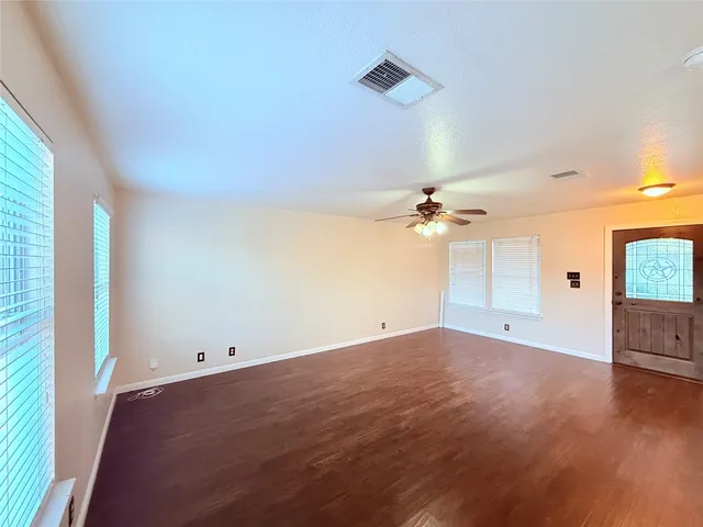 wooden floor in an empty room with a window