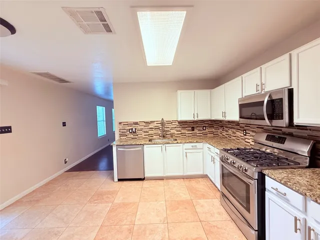 a kitchen with stainless steel appliances granite countertop a stove and a sink