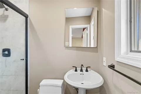 a bathroom with a sink a toilet and a mirror